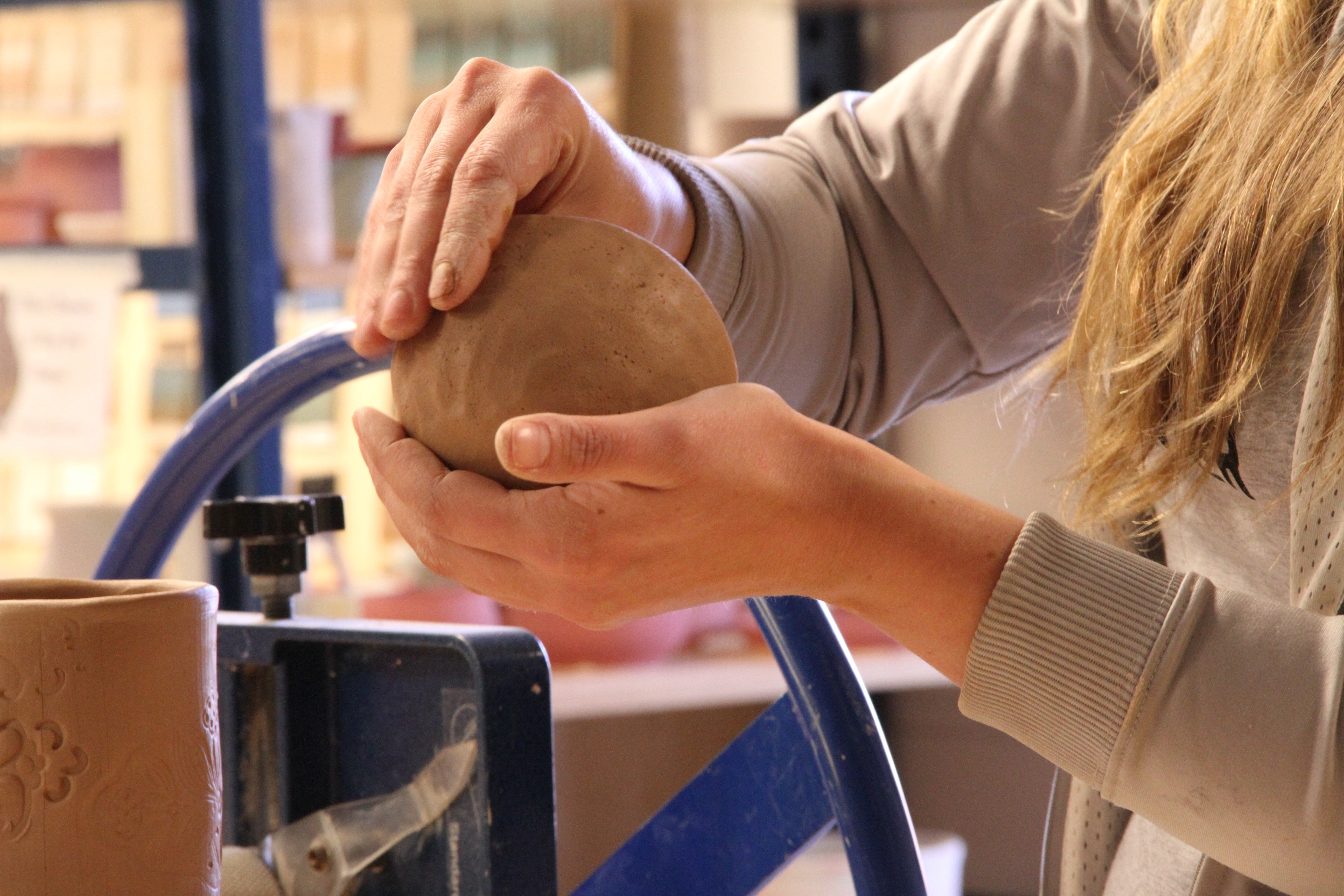 Close up of hands making a ceramic pinch pot
