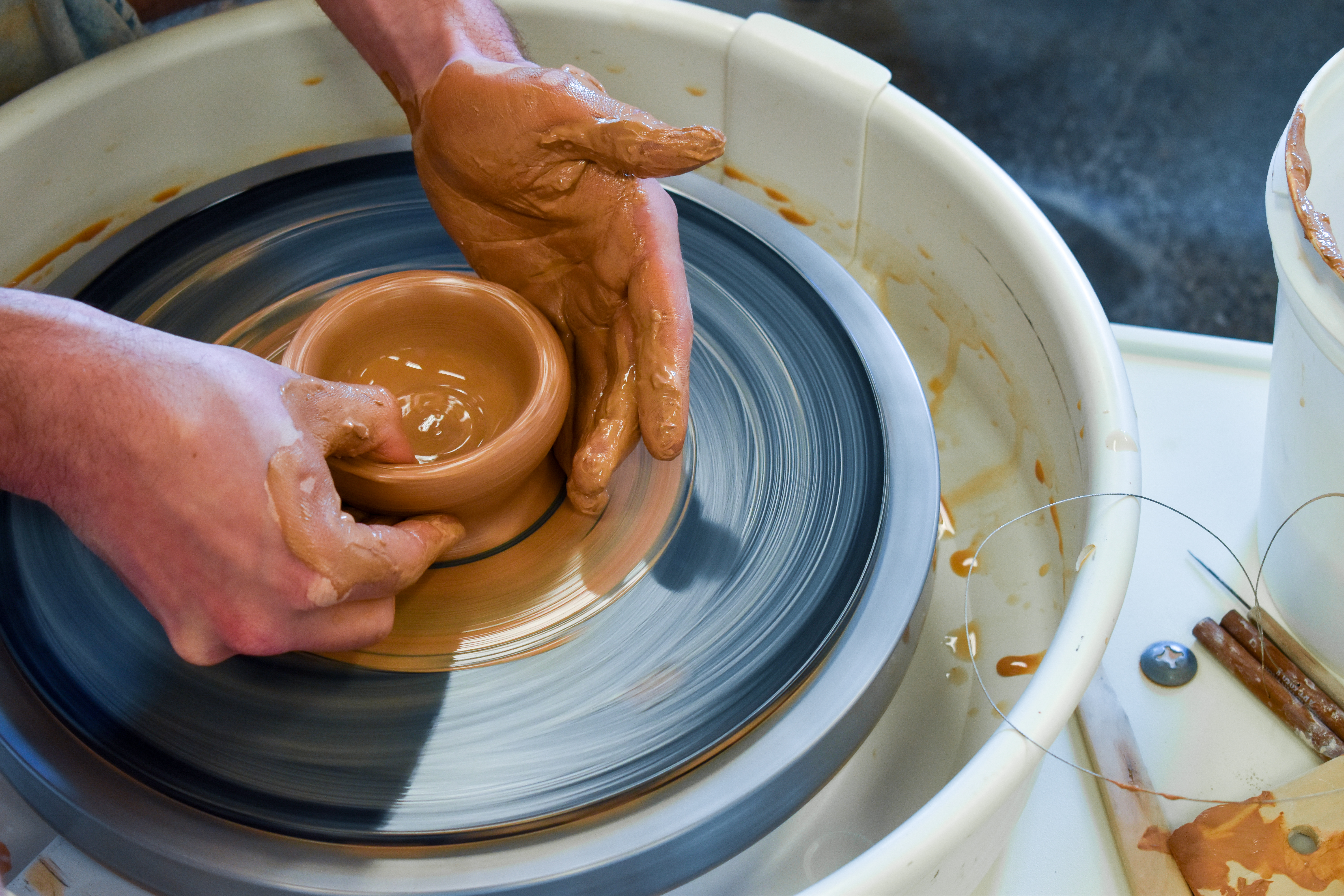 Red clay being thrown on wheel