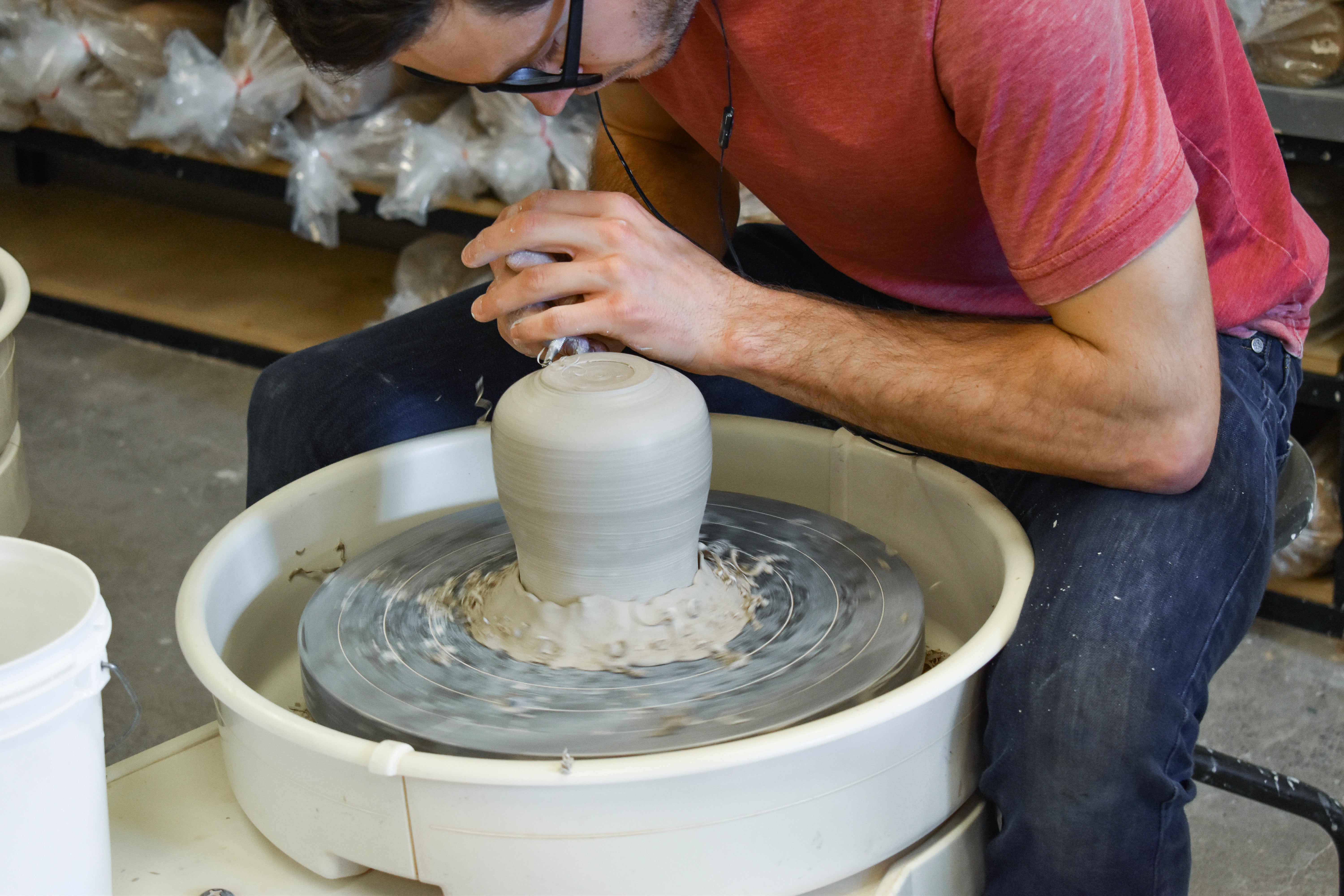 Person throwing vase on wheel