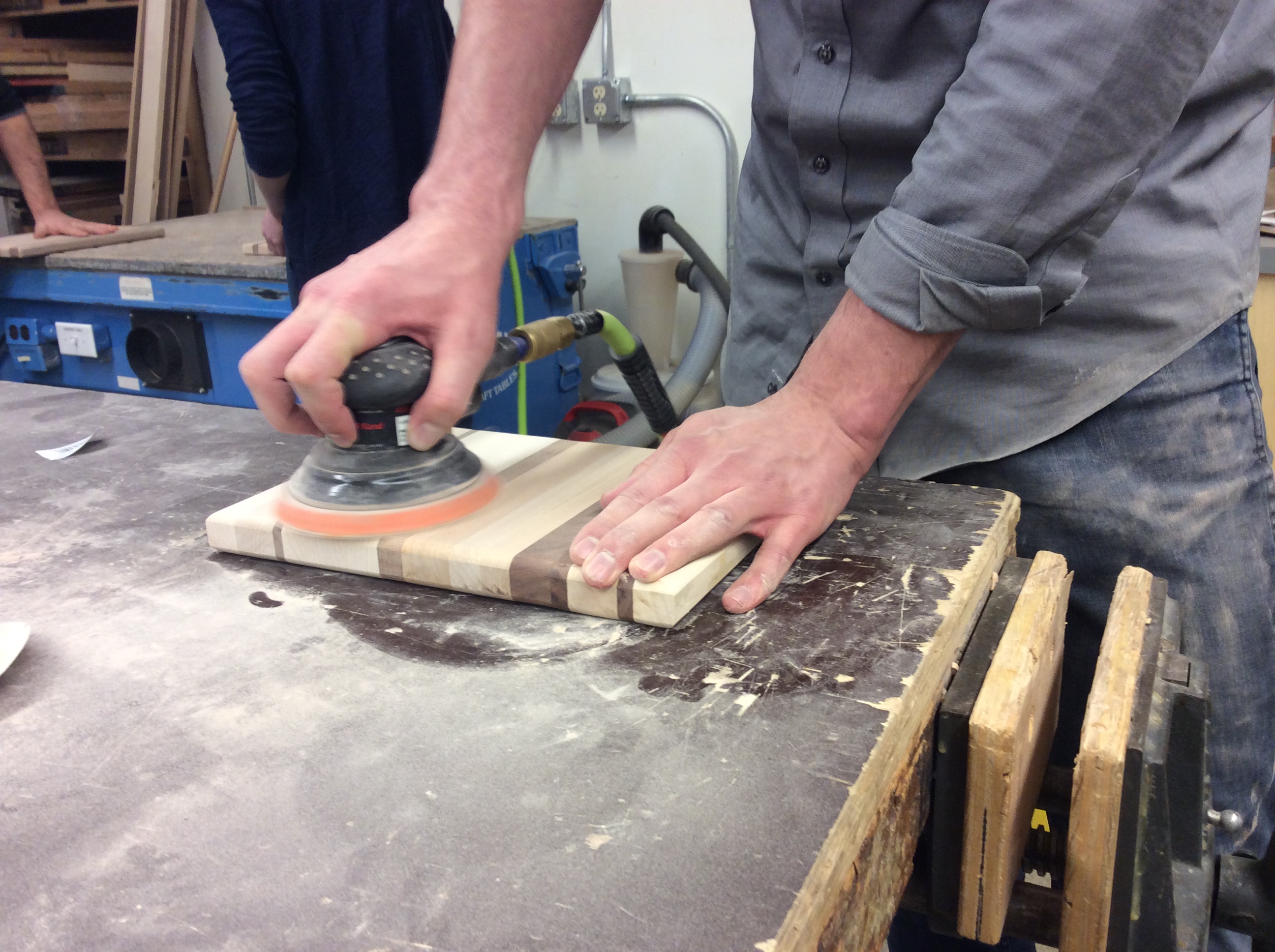 Person sanding a cutting board