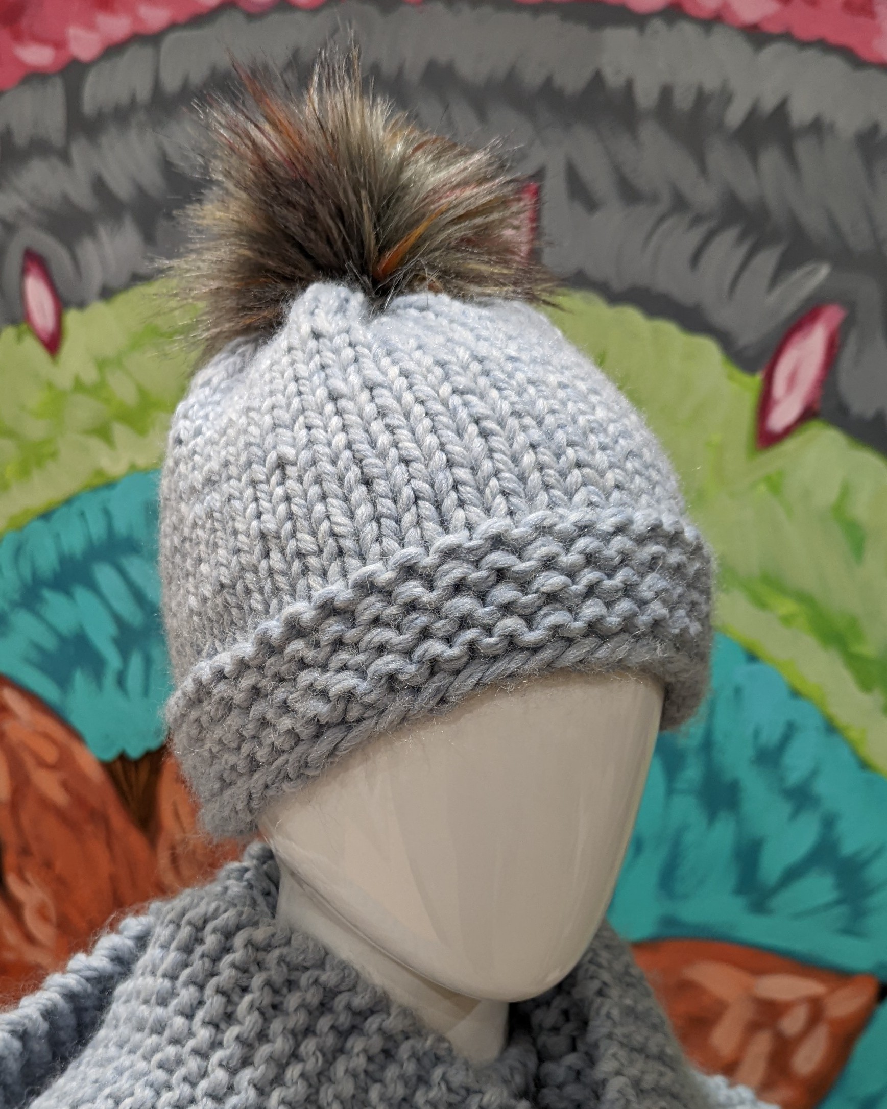 Knit hat with furry pom on top. 