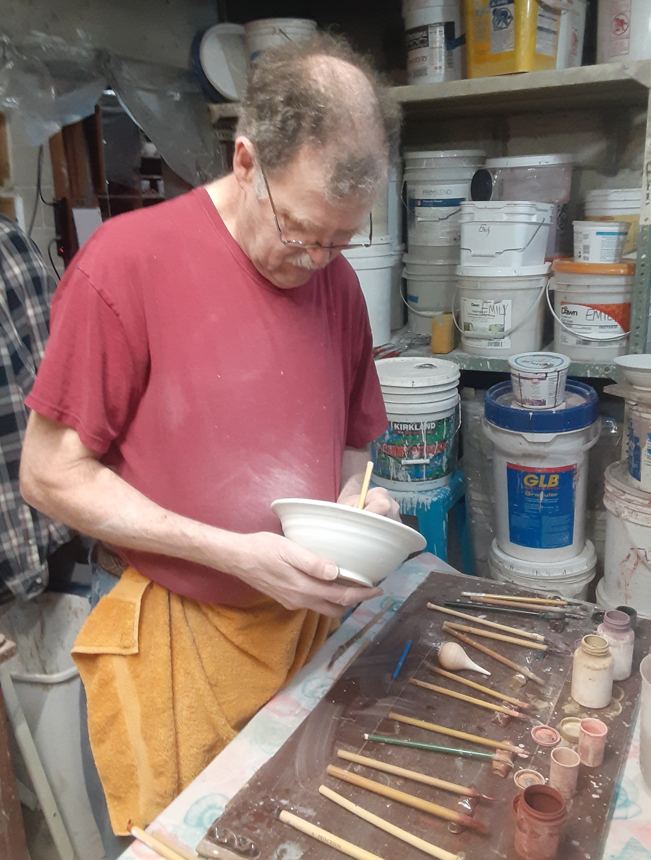 Frank Gosar painting pottery in his studio
