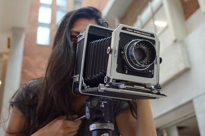 Student using folding camera to take photos.