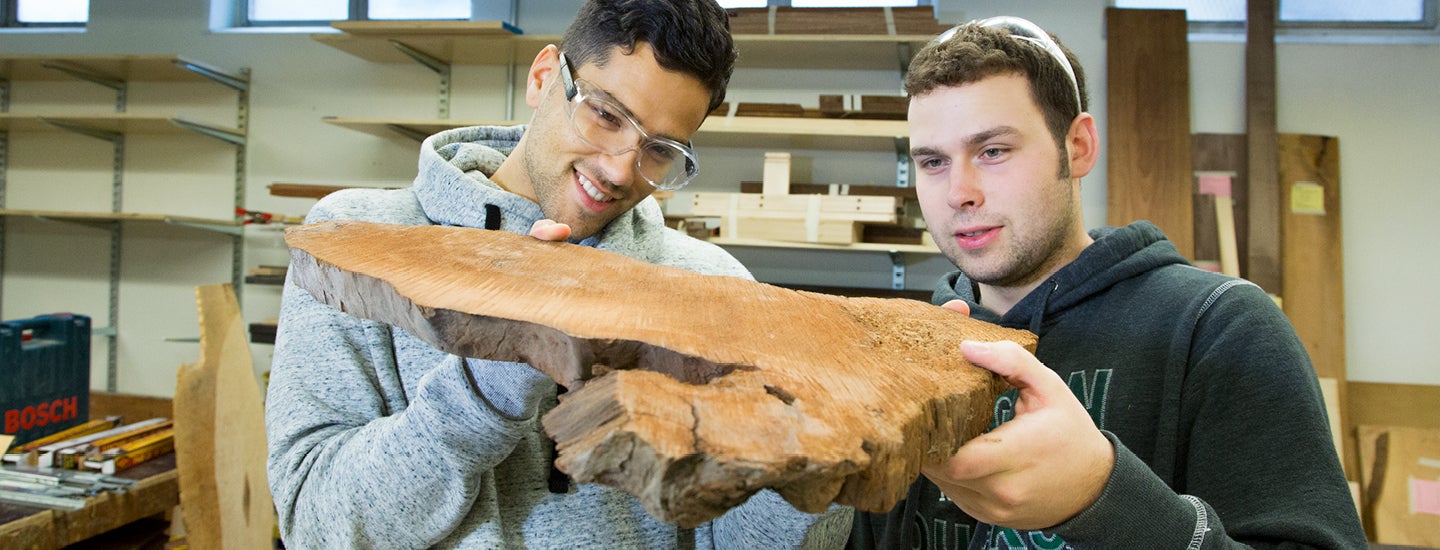 Craft Center members examining cut wood.