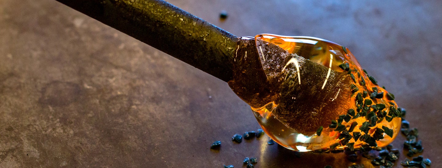 Rolling molten glass in speckled material.