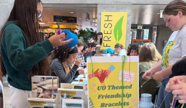 Students create friendship bracelets at a Freebie Fridays event in the EMU by the O Desk.