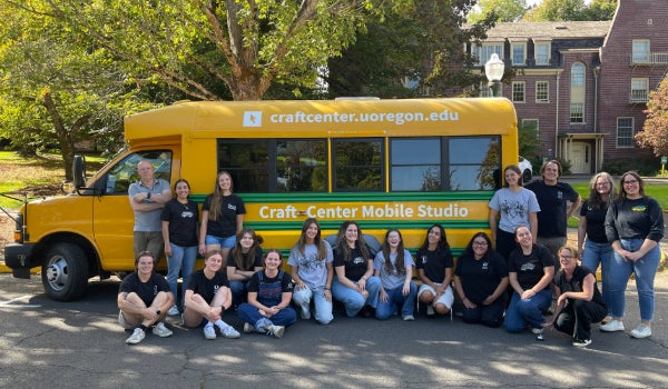 Staff poses in front of the mobile studio bus.